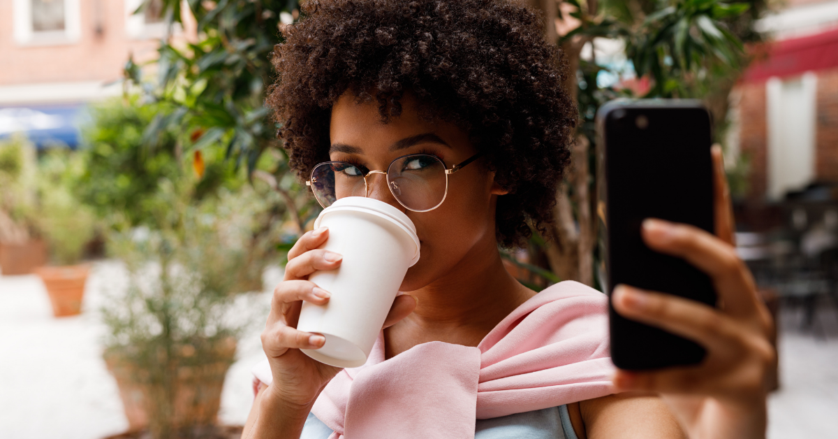 Woman drinking coffee and taking a selfie