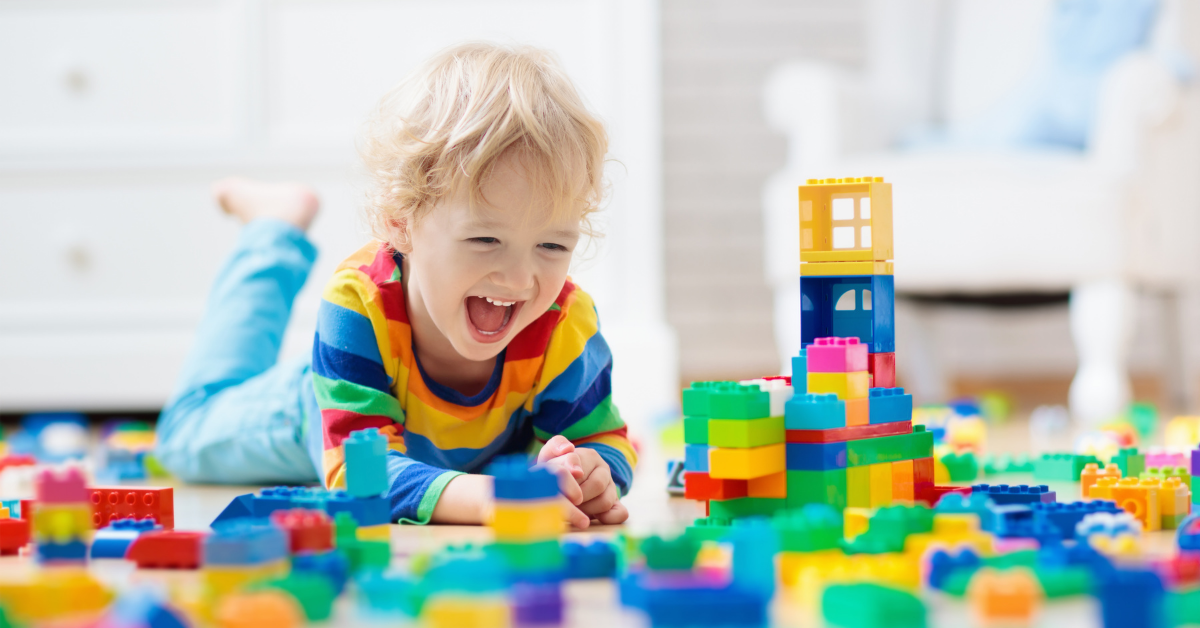 Extatic kid playing with lego