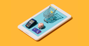 A shopping cart, a piggy bank and a credit card placed on a tablet